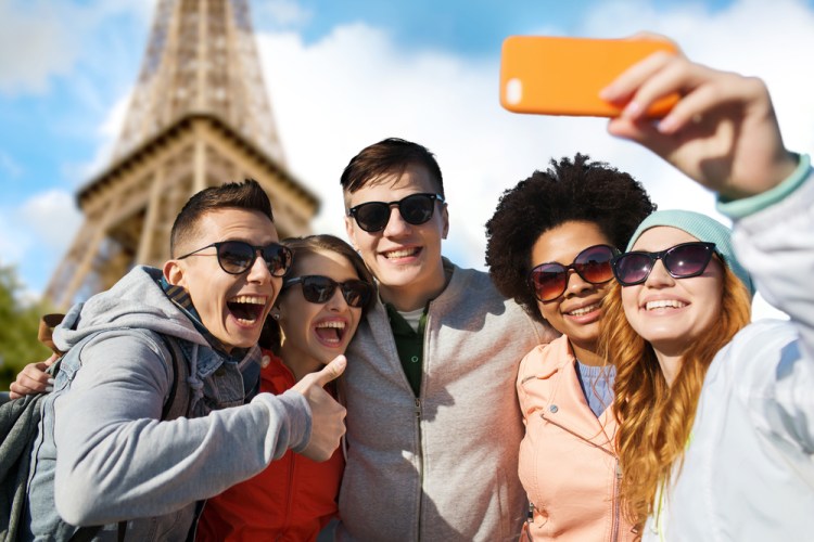 smiling friends taking selfie with smartphone